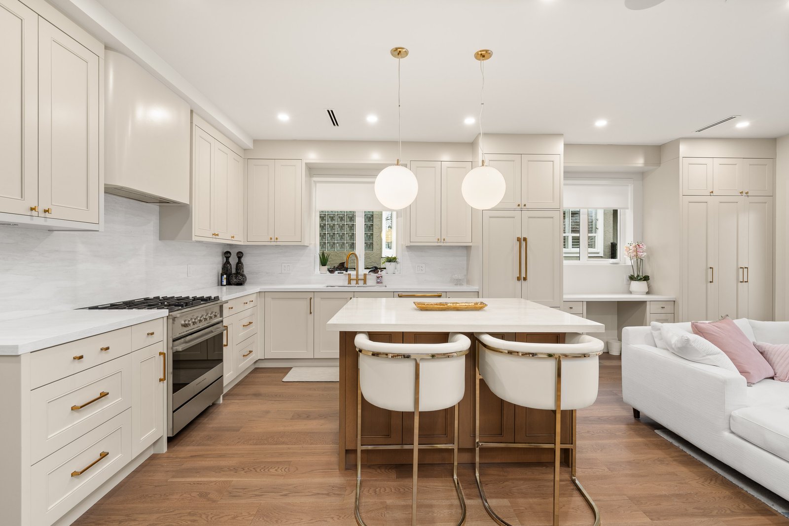 Bright white kitchen with centre island, pendant lights and wood flooring
