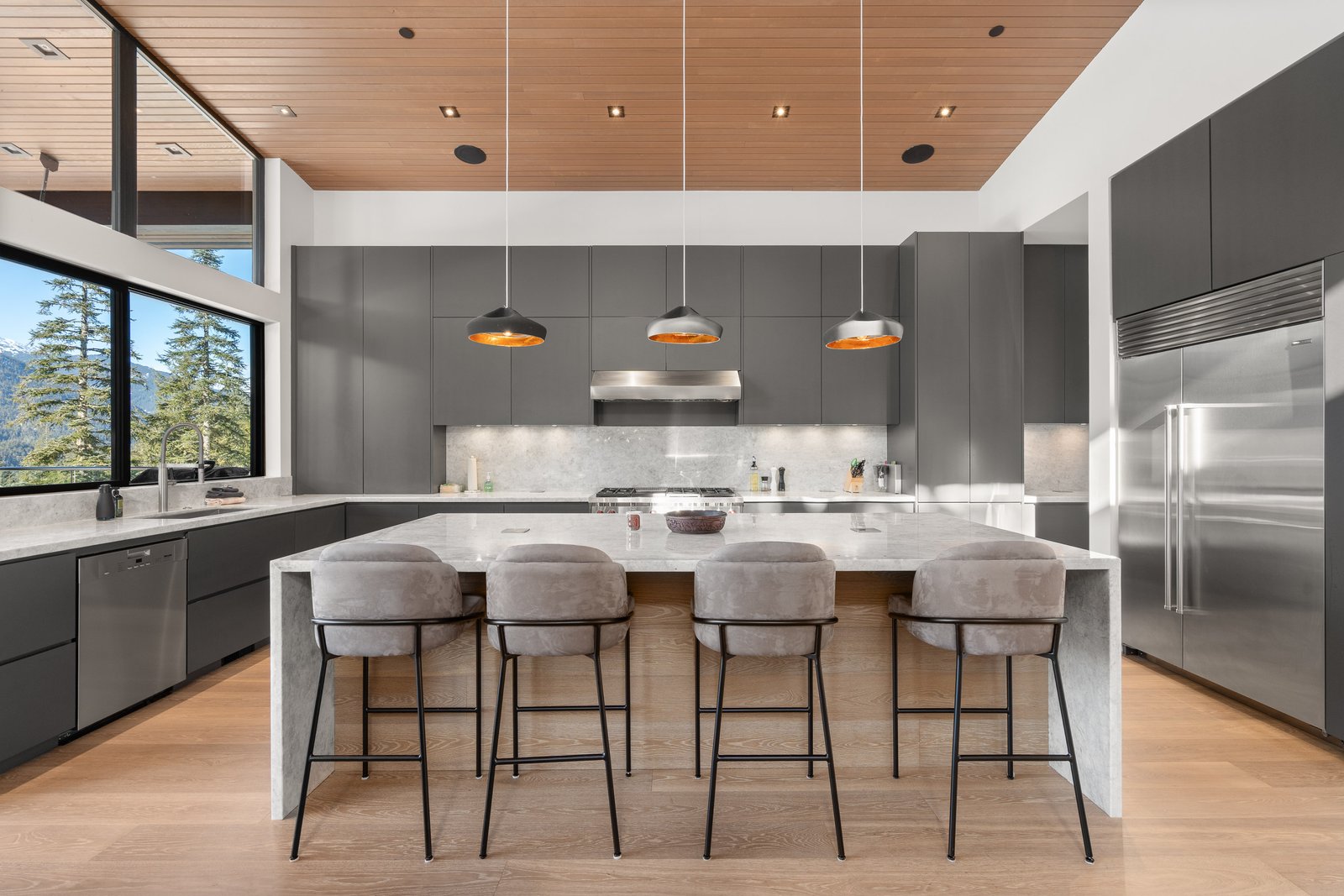 Contemporary grey kitchen with marble island, bar seating and mountain views