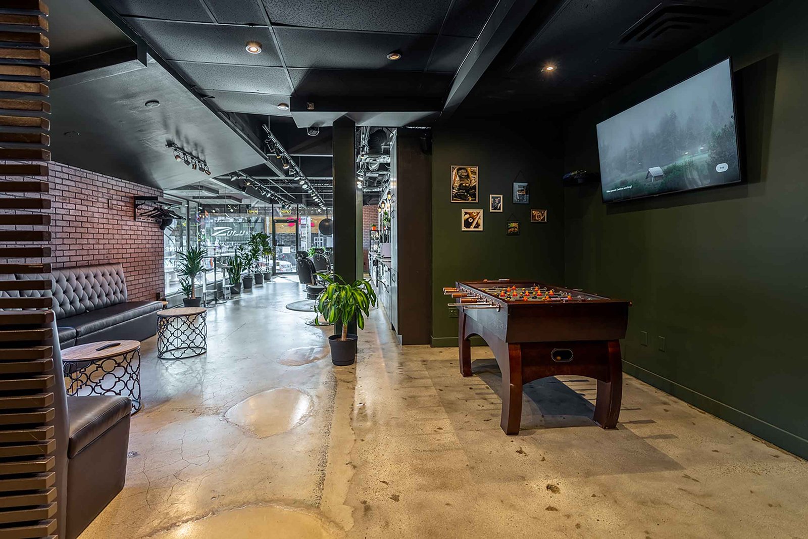 Interior of El Baron barbershop in Kitsilano, Vancouver, featuring a lounge area and foosball table.