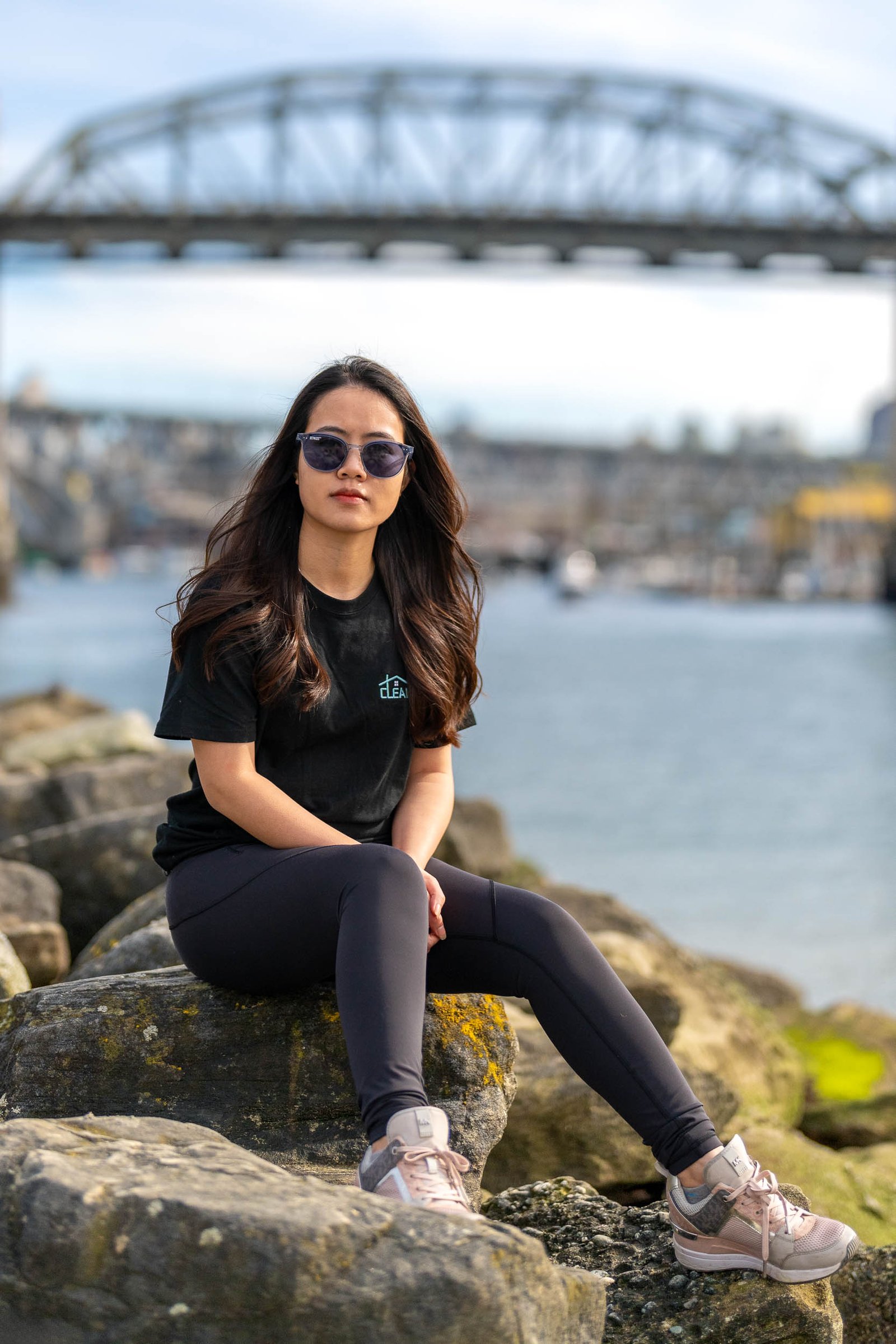 a woman sitting on rocks by water